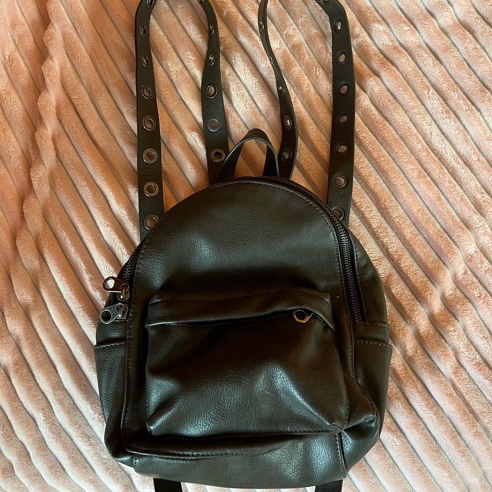 Army green faux leather backpack with grommet detailing on straps